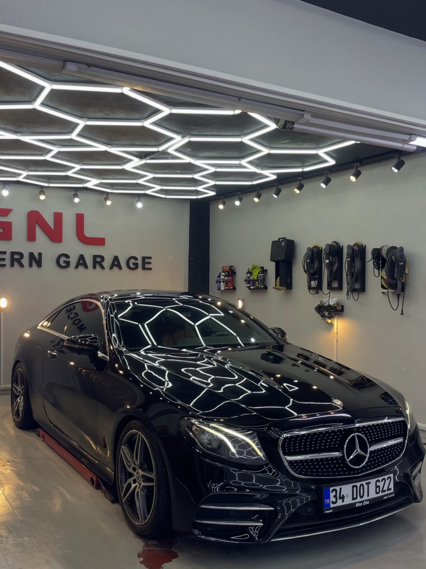 Siyah Mercedes-Benz E Serisi Coupé atölye içinde parlak yüzeyiyle